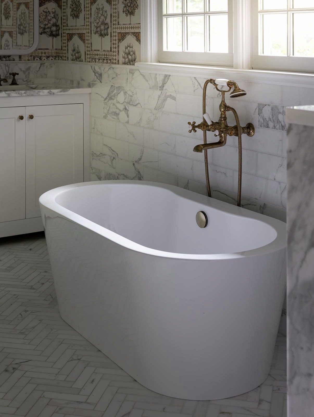 Freestanding tub with an antique brass filler in the Muttontown primary bath